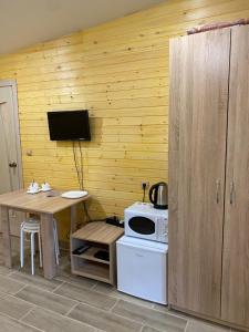 a kitchen with a table and a stove and a microwave at Touristic complex Taiezhnik in Manzherok