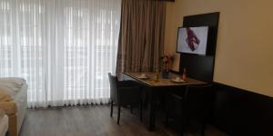 um quarto de hotel com uma mesa com cadeiras e uma janela em Apartment Hotel City Inn em Colónia