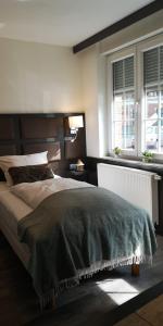 a bedroom with a large bed and two windows at Apartment Hotel City Inn in Cologne