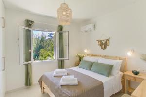 a bedroom with a bed with two towels on it at Casa Micallef Corfu in Kontokali