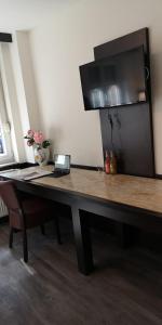 einen Holztisch mit einer Blumenvase darauf in der Unterkunft Apartment Hotel City Inn in Köln