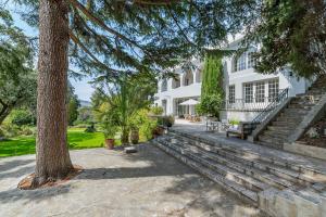 Una gran casa blanca con un árbol y escaleras en Domaine Maraspar Cassis, en Cassis