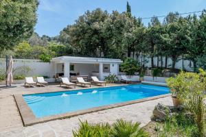 una piscina en un patio con sillas y una casa en Domaine Maraspar Cassis, en Cassis