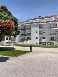 een groot appartementencomplex met een boom ervoor bij VMO Apartment in Vila do Conde