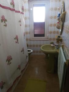 La salle de bains est pourvue d'un lavabo et d'un rideau de douche. dans l'établissement RENT ROOM JOE Via Dante 77 Solarino, à Solarino