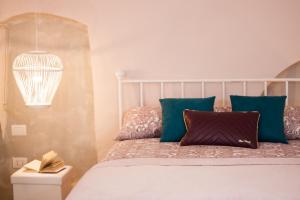 ein Schlafzimmer mit einem Bett mit blauen Kissen in der Unterkunft Iconica in Putignano