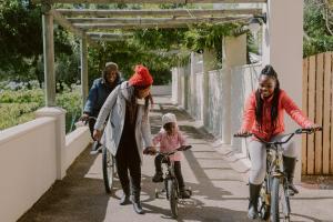 Eine Gruppe von Menschen, die auf einem Bürgersteig Fahrrad fahren in der Unterkunft Spier Hotel and Wine Farm in Stellenbosch