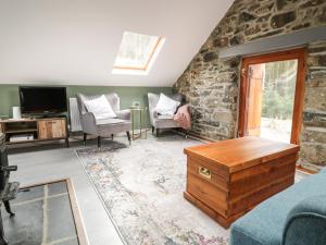 a living room with two chairs and a tv at Brithgwm Canol in Dolgellau