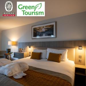 a hotel room with two beds and a sign that reads green tourism at Maldron Hotel Smithfield Dublin City in Dublin