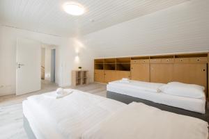 Dos camas en una habitación grande con paredes blancas. en Tolstov House - Freistehendes 9 Zimmer Haus mit großem Garten, en Pulheim