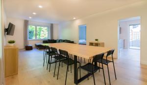 uma sala de jantar e sala de estar com uma mesa de madeira e cadeiras em RAJ Living - Freistehendes 9 Zimmer Haus mit großem Garten em Pulheim