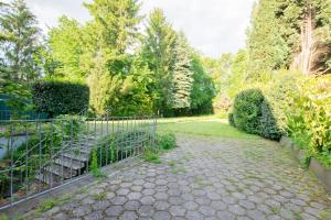 Un jardín con una valla y un camino. en Tolstov House - Freistehendes 9 Zimmer Haus mit großem Garten, en Pulheim