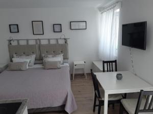 a bedroom with a bed and a table and a television at Apartments Kule in Brela