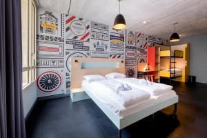 a bedroom with a wall covered in stickers at MEININGER Hotel Bordeaux Gare Saint-Jean in Bordeaux