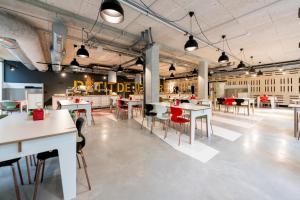 a dining room with tables and chairs in a building at MEININGER Hotel Bordeaux Gare Saint-Jean in Bordeaux