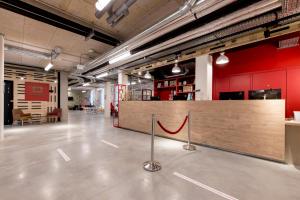 a large room with a counter and red walls at MEININGER Hotel Bordeaux Gare Saint-Jean in Bordeaux