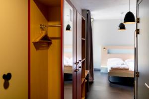 a room with a door and a bedroom with a bed at MEININGER Hotel Bordeaux Gare Saint-Jean in Bordeaux