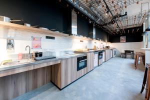 a large kitchen with a sink and a counter at MEININGER Hotel Bordeaux Gare Saint-Jean in Bordeaux