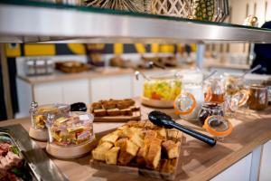 a buffet line with different types of food on a counter at MEININGER Hotel Bordeaux Gare Saint-Jean in Bordeaux