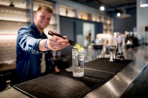 a man is preparing a drink at a bar at MEININGER Hotel Bordeaux Gare Saint-Jean in Bordeaux