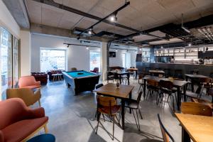 a restaurant with tables and a pool table at MEININGER Hotel Bordeaux Gare Saint-Jean in Bordeaux