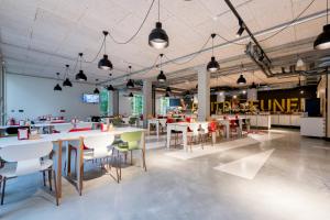 a restaurant with tables and chairs in a room at MEININGER Hotel Bordeaux Gare Saint-Jean in Bordeaux