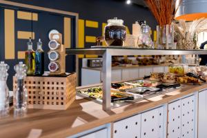 a buffet in a restaurant with food on a counter at MEININGER Hotel Bordeaux Gare Saint-Jean in Bordeaux