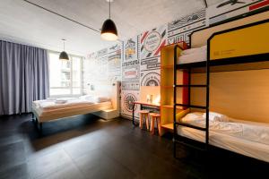 a room with two bunk beds and a wall with graffiti at MEININGER Hotel Bordeaux Gare Saint-Jean in Bordeaux
