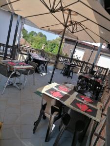 a patio with tables and chairs and an umbrella at Le Fair Play in Léon