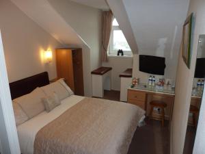 a bedroom with a bed and a desk and a television at Lavinia House in Whitby