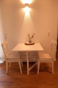 uma mesa e duas cadeiras com uma mesa branca e uma luz em Waldurlaub Klingelborn im Sauerland em Balve