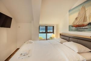 sypialnia z dużym łóżkiem i obrazem żaglówki w obiekcie Doxa M Apartments w mieście Herceg Novi