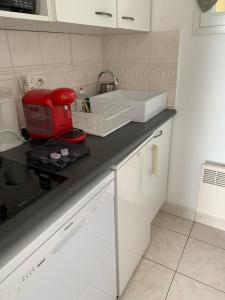 a red toaster sitting on a counter in a kitchen at Cap Bleu in Blonville-sur-Mer +22 photos