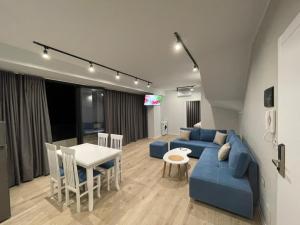 a living room with a blue couch and a table at Sunny Hill Residence in Vlorë