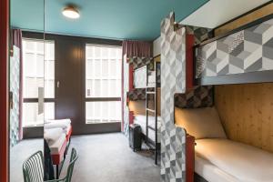 Un pat sau paturi într-o cameră la MEININGER Hotel Zürich Greencity