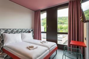 Un pat sau paturi într-o cameră la MEININGER Hotel Zürich Greencity