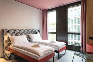 Un pat sau paturi într-o cameră la MEININGER Hotel Zürich Greencity