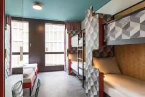 Un pat sau paturi într-o cameră la MEININGER Hotel Zürich Greencity