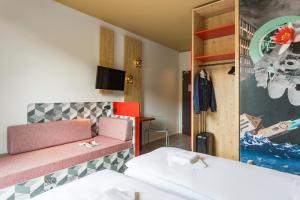 Un pat sau paturi într-o cameră la MEININGER Hotel Zürich Greencity