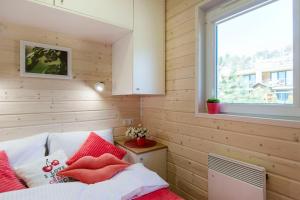 um pequeno quarto com uma cama e uma janela em Cherry House Gdańsk em Gdansk