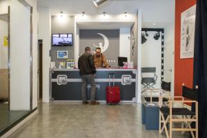 deux hommes debout à un comptoir dans un magasin dans l'établissement Casual del Cine Valencia, à Valence