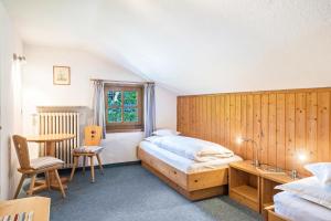 a bedroom with two beds and a desk and a table at Baumgartnerhof Appartment Magnolie in Lagundo