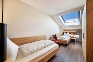 sypialnia na poddaszu z łóżkiem i oknem w obiekcie Ferienwohnung Zypresse w Meranie