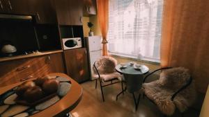 uma sala de estar com uma mesa e cadeiras e uma televisão em Apartament Pilsko 1 em Korbielów