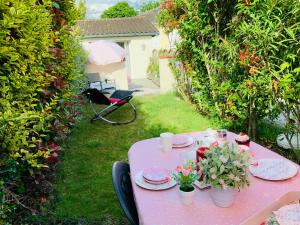 einen rosa Tisch mit Platten und Blumen darauf in der Unterkunft Cottage Blagnac in Beauzelle + 4 Fotos