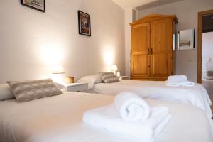 a bedroom with two beds with towels on them at Casa Pelaire Biescas in Biescas