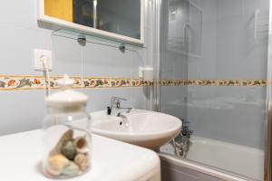 a white bathroom with a sink and a shower at Casa Pelaire Biescas in Biescas +10 photos