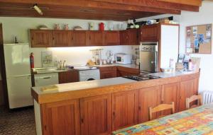 ダンモア・イーストにあるWreckers Cottageのキッチン(木製キャビネット、白い冷蔵庫付)