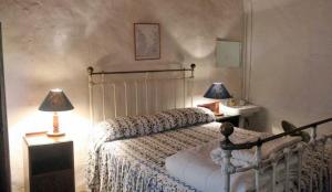 Wreckers Cottage في دونمور إيست: غرفة نوم بها سرير ومصباحين على الطاولات