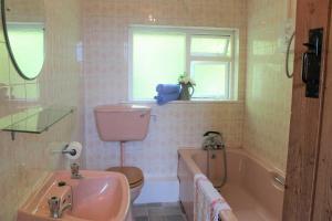 y baño con lavabo, aseo y bañera. en Wreckers Cottage en Dunmore East